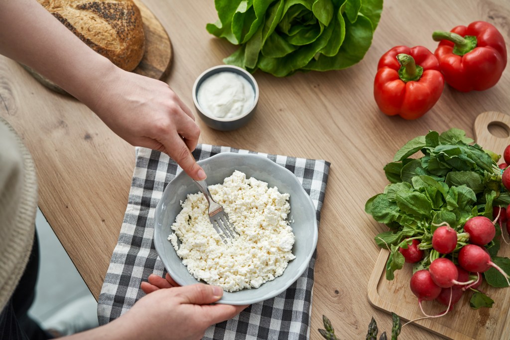 Overhead view of a woman preparing spring cottage cheese sandwiches